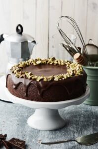 Indulge in this luxurious chocolate cake topped with crunchy pistachios.